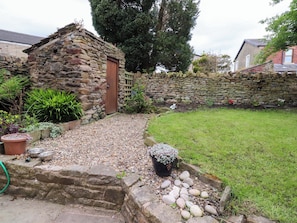 A stone building with a wooden door, surrounded by a stone wall and a grassy area. - 6 Hazel Moor (Blackburn)