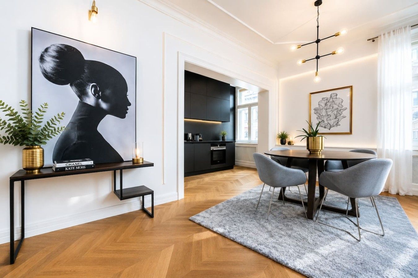 A modern dining area with a dark wood table, grey upholstered chairs, and a grey rug.