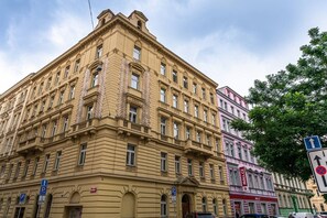 Ein mehrstöckiges Gebäude im klassischen Stil, mit einem markanten Eingangsbereich an der Ecke und zahlreichen Fenstern.