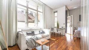 Ein modernes Wohnzimmer mit Sofa, Couchtisch und Essbereich.