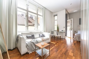 Ein modernes Wohnzimmer mit Sofa, Couchtisch und Essbereich.