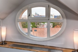 Ein Zimmer mit einem großen Rundfenster, einem Heizkörper und zwei Wandleuchten.