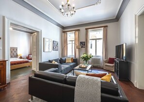 Ein modernes Wohnzimmer mit einer Sofagarnitur, einem Couchtisch und einem Fernseher.