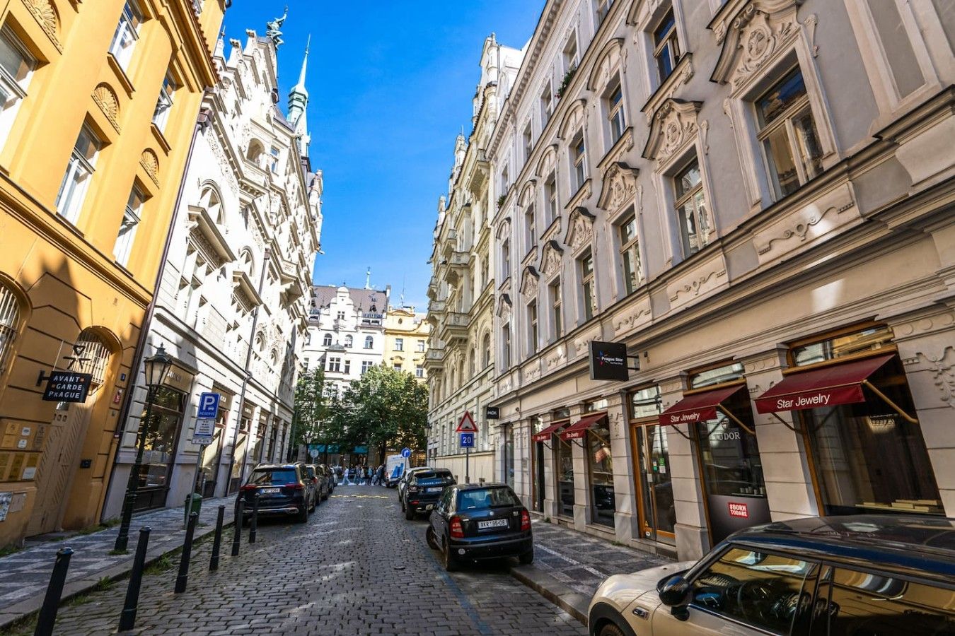 A cobblestone street lined with historic buildings, a Star Jewelry store, and a parking sign indicating a 20-minute parking limit.
