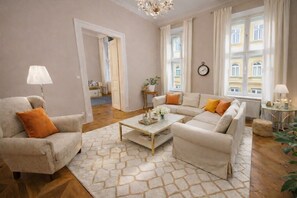 Ein Wohnzimmer mit einer Sofagarnitur, einem Couchtisch und einer Lampe.