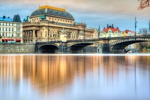 Ein historisches Gebäude mit einer markanten Kuppel und einer Brücke über einem ruhigen Fluss.