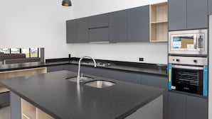 A modern kitchen with a central island, stainless steel appliances, and a built-in oven. - Gdl Sky Luxury residence (Zapopan)