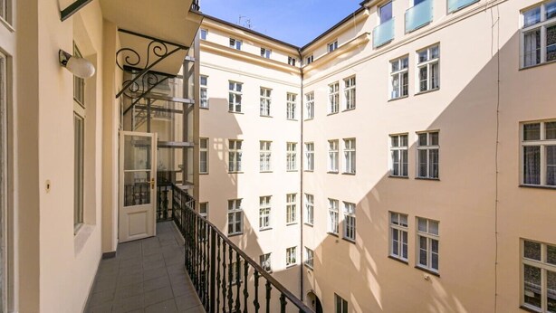 En byggnad med flera våningar, en balkong, en dörr och fönster.