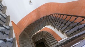 En spiraltrappa med en böjd design, metallräcken och en vit vägg.