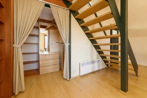 A room with a wooden staircase, a built-in wardrobe, and a radiator. - Old Town Penthouse with Prague Castle Views (Prague)