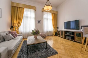 Ein Wohnzimmer mit einer Couch, einem Couchtisch, einem Fernseher und einer Unterhaltungsanlage.