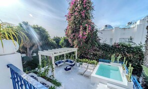 Ein Dachgarten mit Pool, Sitzgelegenheiten im Freien und einer Pergola.