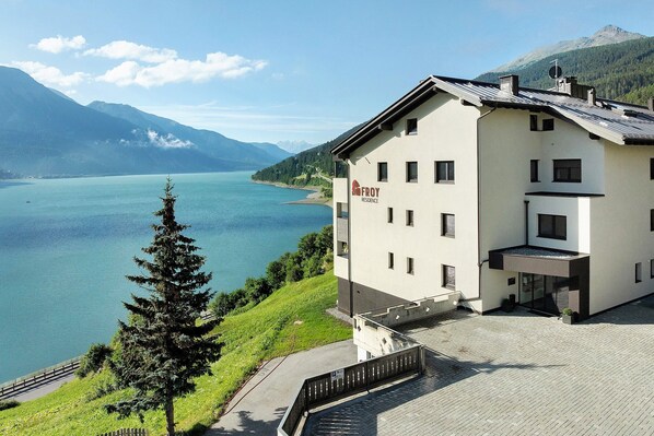 Un bâtiment moderne offrant une vue sur un lac et des montagnes.