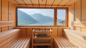 A wooden sauna with benches and a window offering a mountain view. - Residence Froy Apartment 1 – Lake View, Whirlpool & Breakfast Included (Graun im Vinschgau)