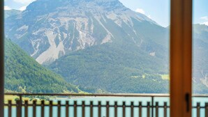 A mountain landscape with a lake and a wooden railing in the foreground. - Residence Froy Apartment 2 – Lake View, Whirlpool & Breakfast Included (Graun im Vinschgau)