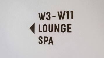 Ein Hinweisschild, das den Bereich für Lounge und Spa anzeigt, mit dem Text 'W3-W11 LOUNGE SPA' und einem nach links zeigenden Pfeil.
