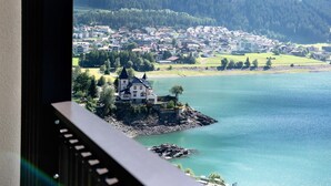 Une ville côtière abritant une maison imposante sur une petite île, entourée d’eau et de verdure.