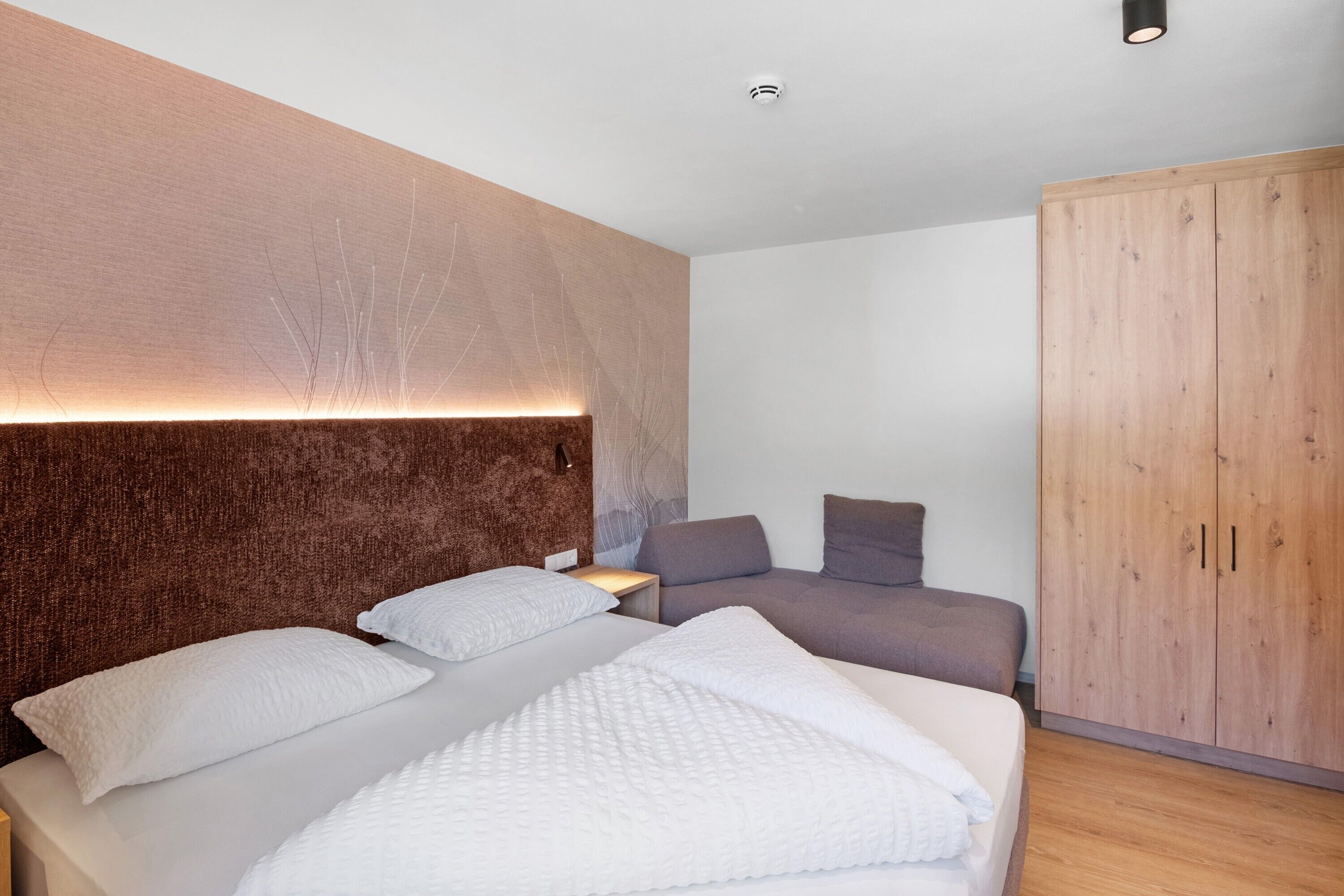 Camera da letto moderna con un letto grande, una poltrona, un armadio e un comodino.