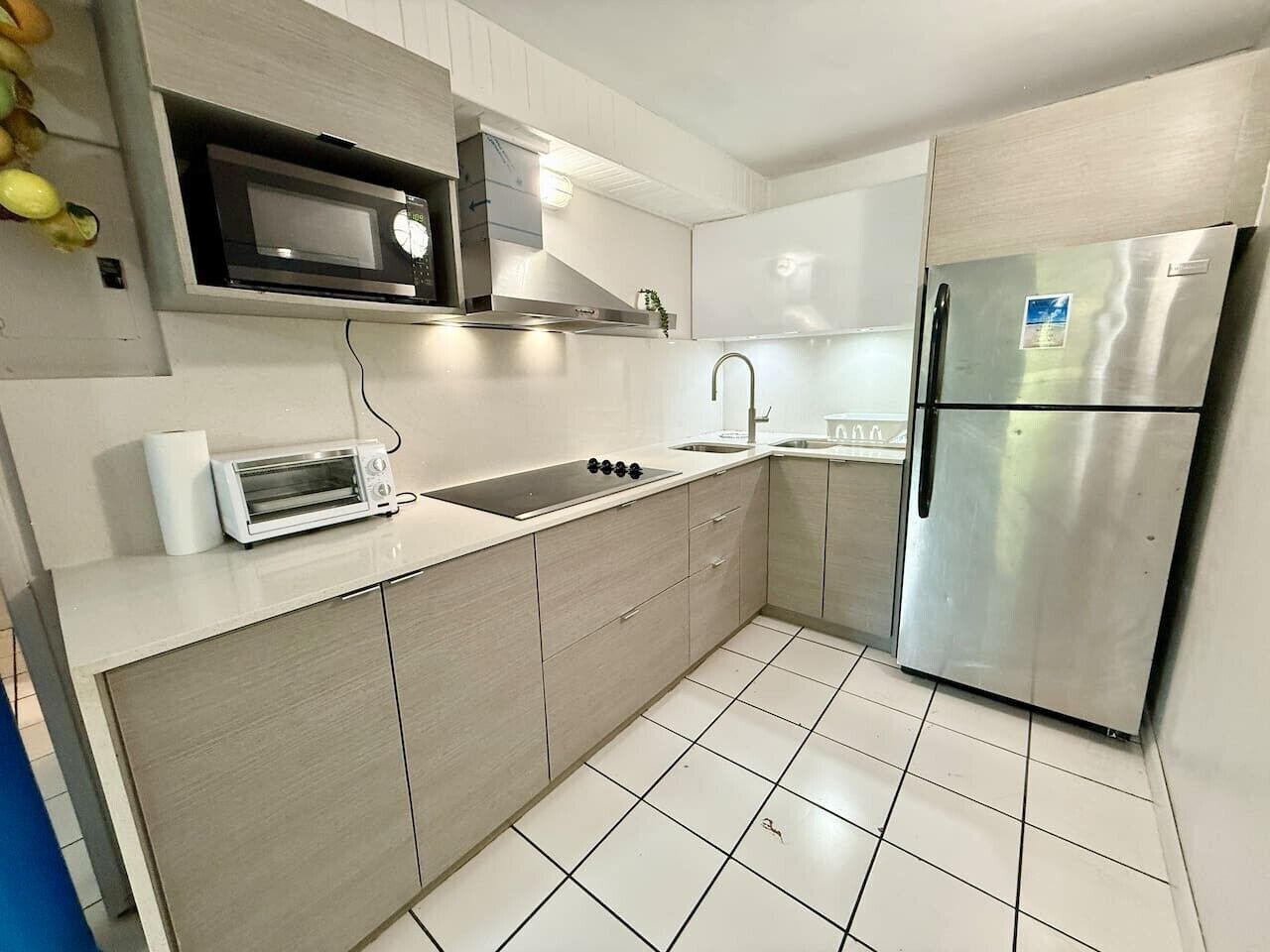 Eine moderne Küche mit Mikrowelle, Toaster, Spüle und einem Edelstahl-Kühlschrank.