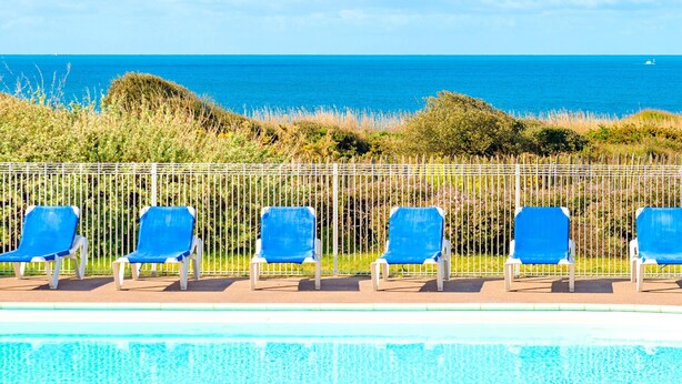 A poolside area with blue chairs and a view of the ocean. - Family Coastal Escape in the Vendee (Les Sables-d'Olonne)