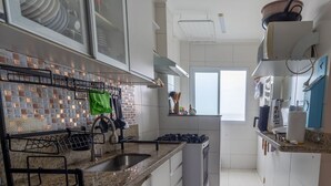 Een moderne keuken met een granieten aanrechtblad, een roestvrijstalen spoelbak en een inbouwoven.