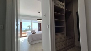 Une chambre à coucher avec un lit, un placard et une vue sur l’océan.