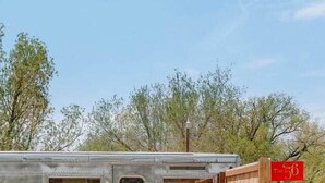 Un camper compatto con un pontile in legno, un'unica area salotto e un piccolo angolo cottura.