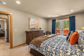 Une chambre à coucher avec un lit, une commode et une vue sur l’extérieur.