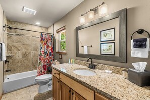Une salle de bain équipée d’une douche, de toilettes, d’un lavabo et d’un meuble-lavabo.