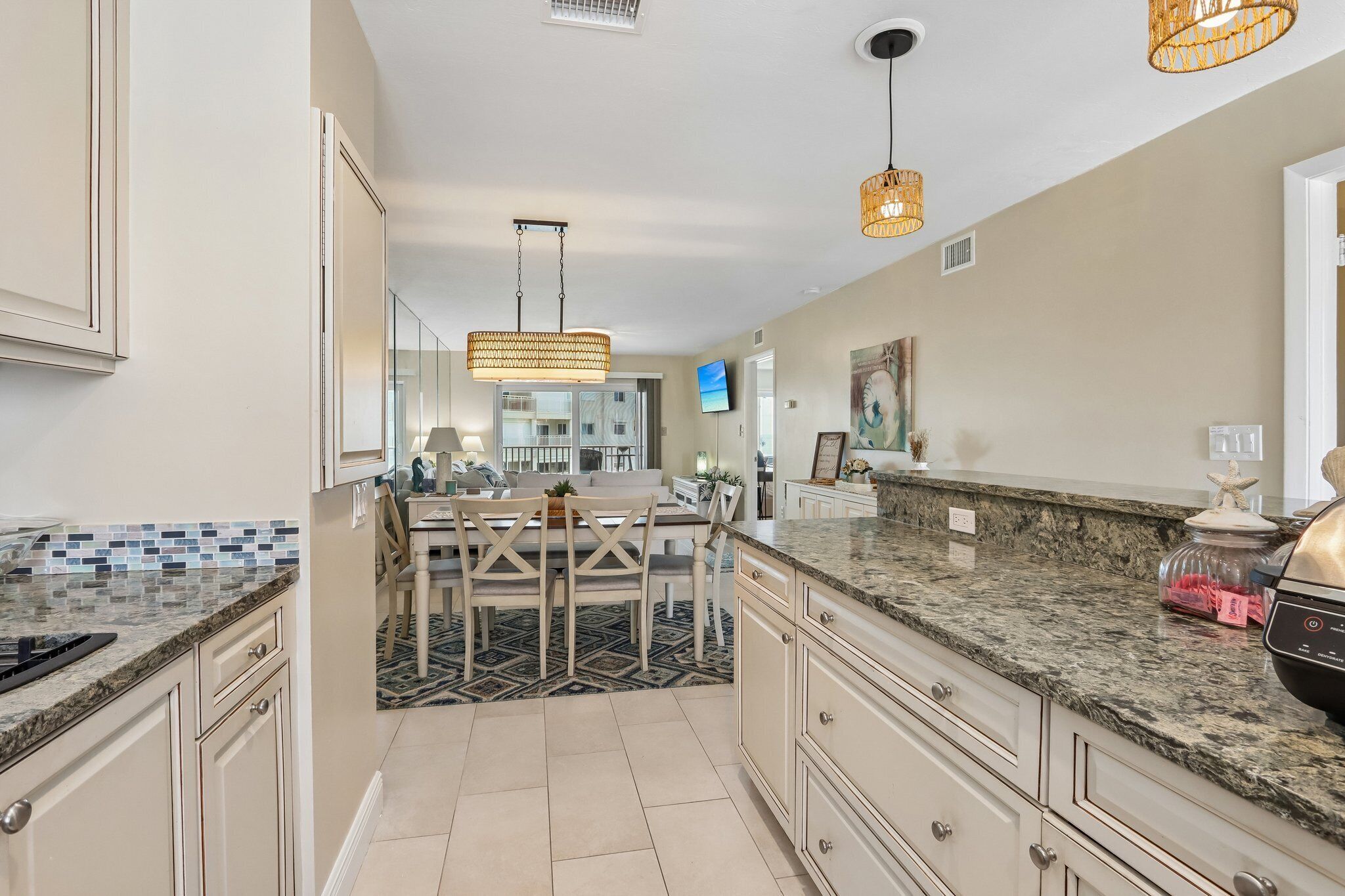 A modern kitchen with a dining area, granite countertops, and a large island.