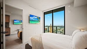 A hotel room with a large bed, a television, a painting, and a view of a cityscape. - Luxury Downtown Miami 501 First Rooftop Pool View (Miami)