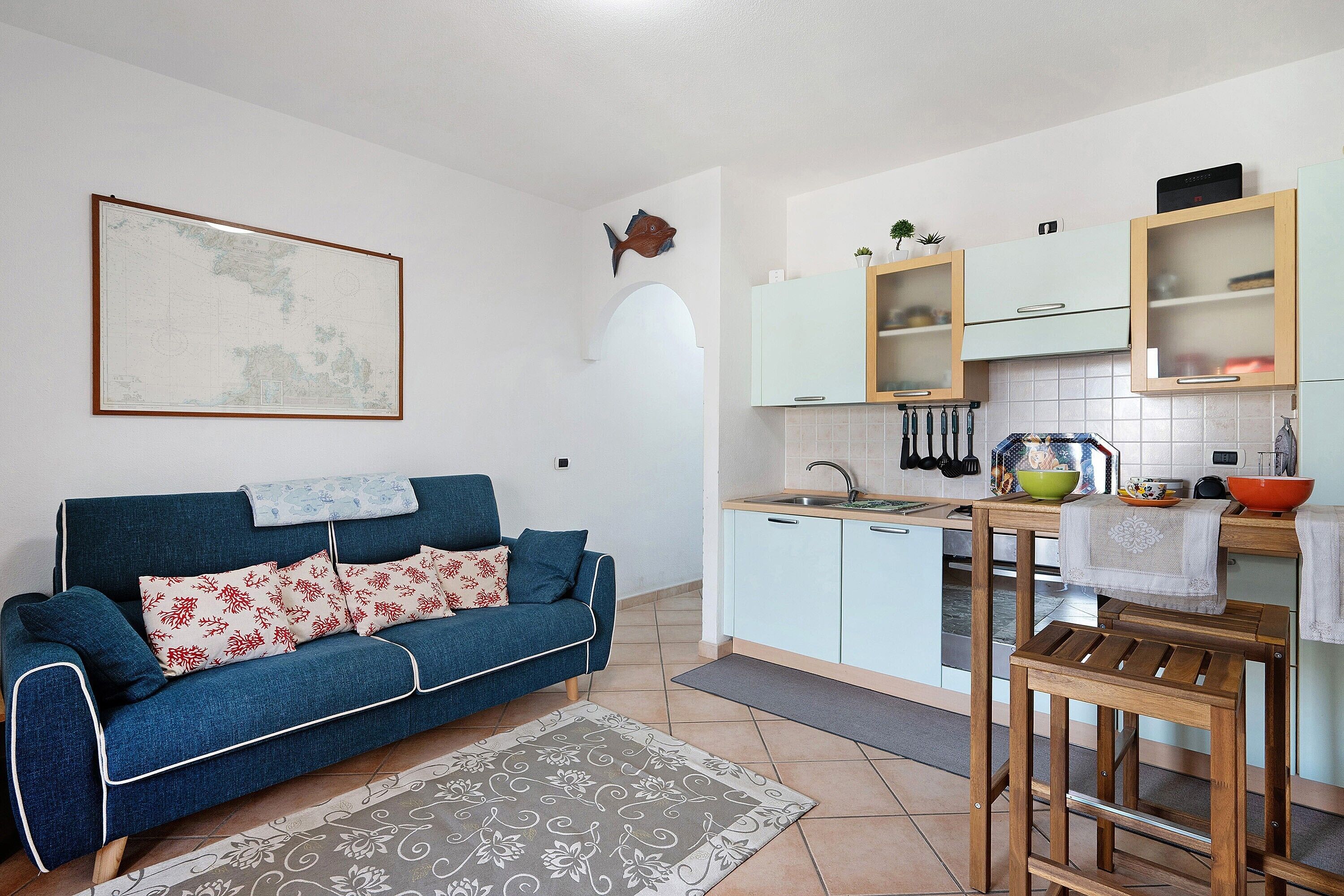 Een ruimtelijke woonkamer met een bank, een eettafel en een keukenhoek.