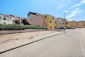 Eine Straße mit bunten Häusern, einem Bürgersteig und einer Straßenlaterne.
