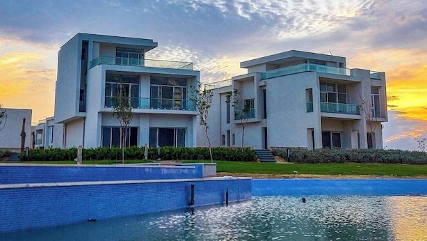 Un edificio moderno con piscina al frente.