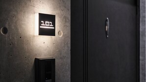 A digital display with the number 101, a door with a handle, and a sign with Japanese text.