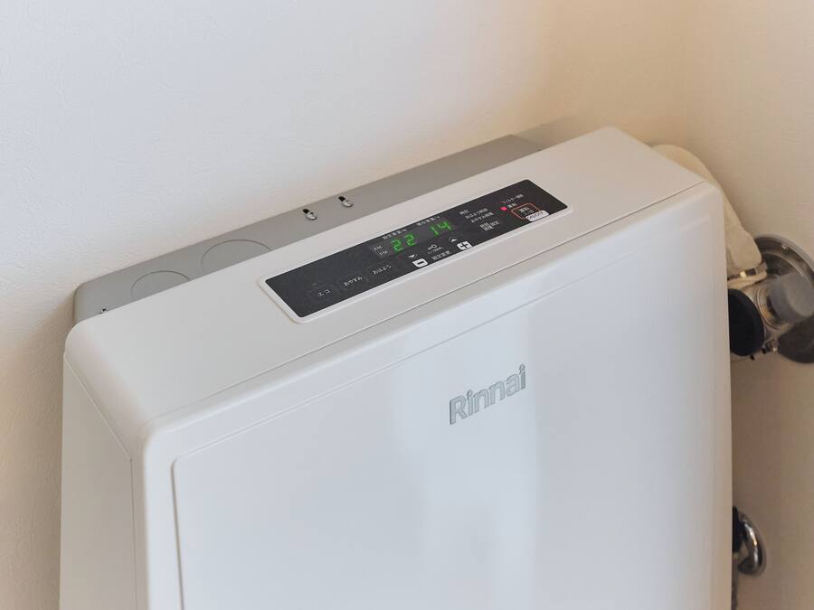 A white Rinnai water heater with a digital display, a control panel, and a silver valve.