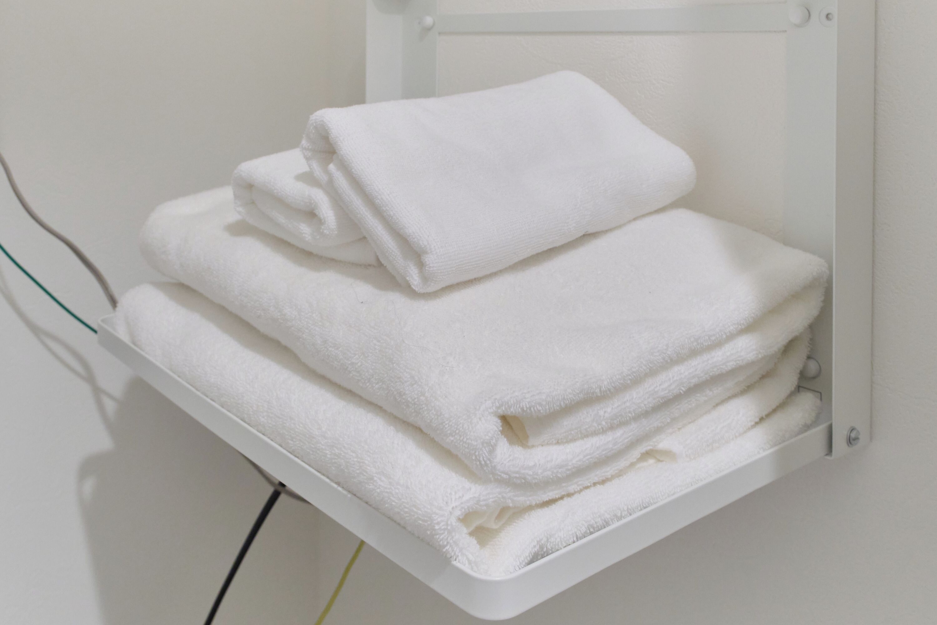 A white towel rack with folded towels.