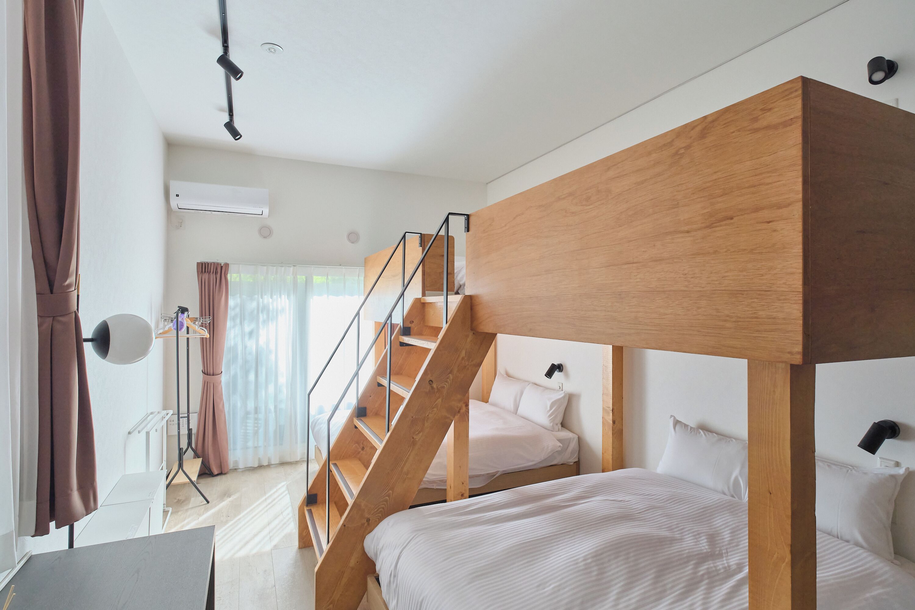 Een moderne slaapkamer met een stapelbed, een bureau en een trap.