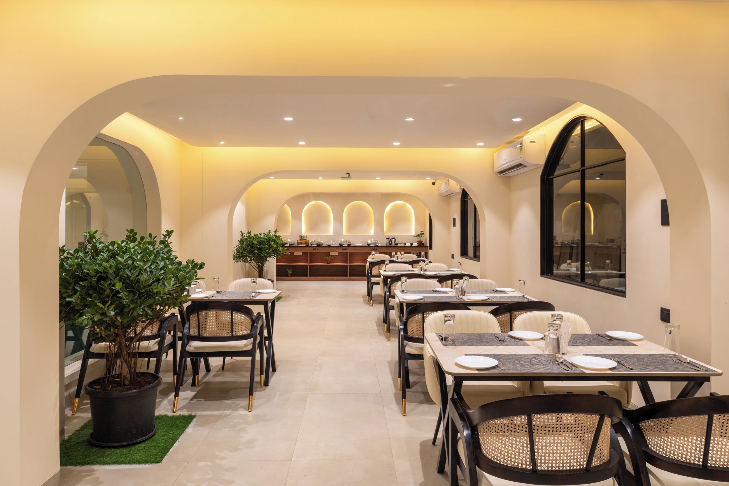 Un restaurante con un amplio comedor, techos abovedados y una barra central.