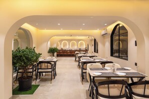 Un restaurante con un amplio comedor, techos abovedados y una barra central.