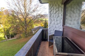 Ein Balkon mit Blick auf Bäume und eine Rasenfläche.
