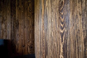 Un primo piano di una superficie in legno con venature e nodi ben visibili.