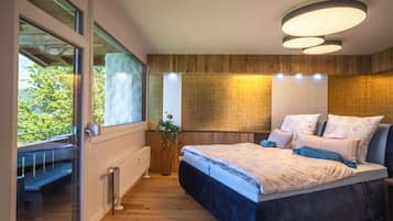 Une chambre avec un grand lit, une fenêtre et un mur en bois.