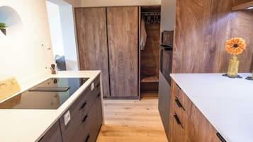 Une cuisine moderne avec des meubles en bois, un plan de travail blanc et un vase à fleurs.