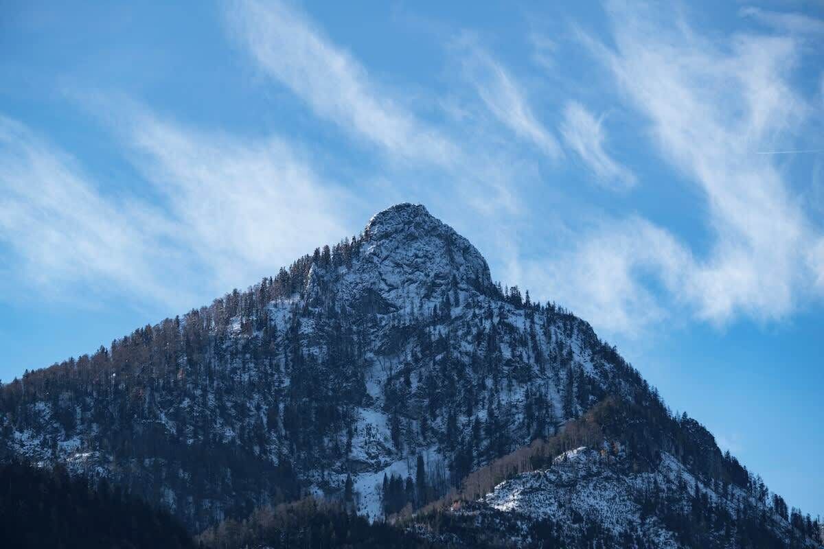 A mountain with a snow-covered peak and a clear sky.