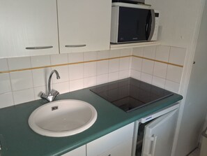 A kitchen with a white sink, a microwave, and a built-in oven. - RÉSIDENCE Lagrange Vacances TURQUOISE (Cavalaire-sur-Mer)