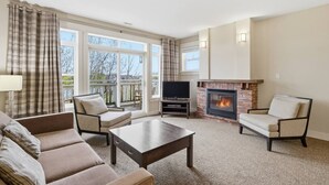 Ein Wohnzimmer mit Kamin, einer Couch, einem Couchtisch und einem Fernseher.