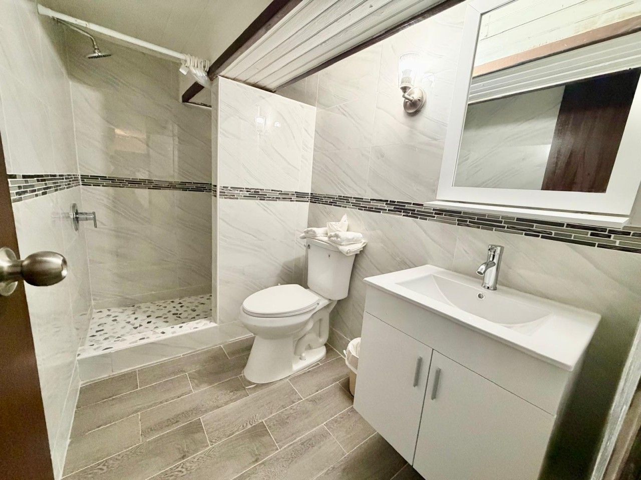 A bathroom with a shower, toilet, and sink.