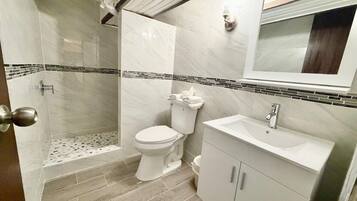 A bathroom with a shower, toilet, and sink.