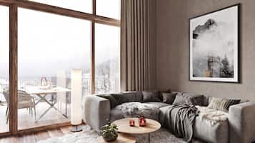 Un salon moderne avec une grande fenêtre, un canapé gris, un tapis blanc et un tableau encadré au mur.